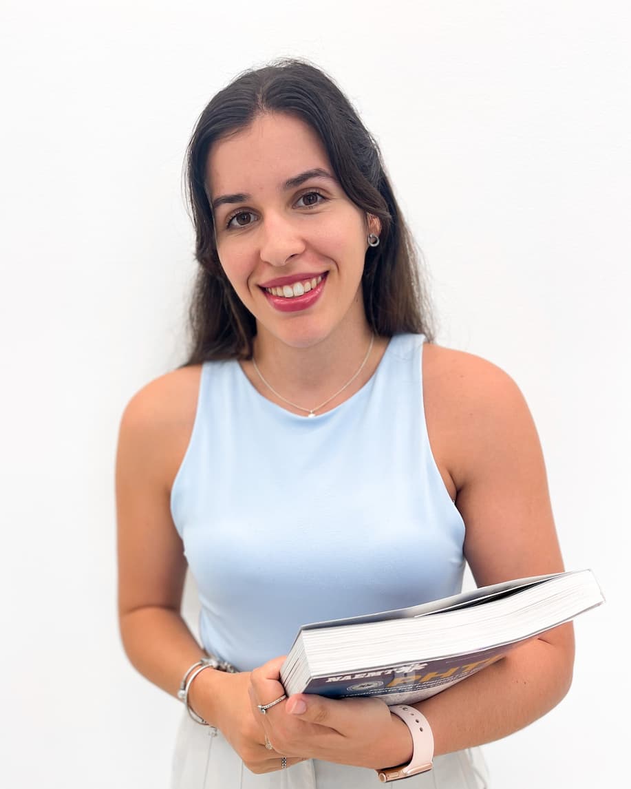 Enfermeira Filipa a segurar um livro de estudo para ajudar na supervisão de trabalhos académicos.